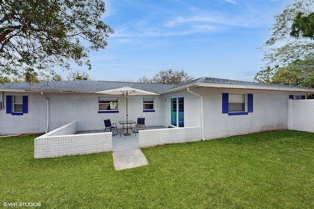 back of house with a yard and a patio