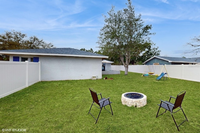 view of yard with a playground and an outdoor fire pit