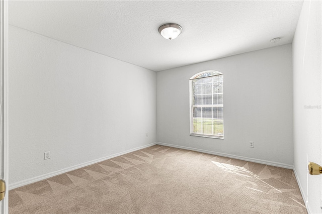 carpeted empty room with a textured ceiling