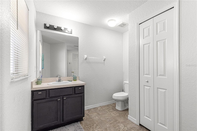 bathroom with vanity, a textured ceiling, and toilet