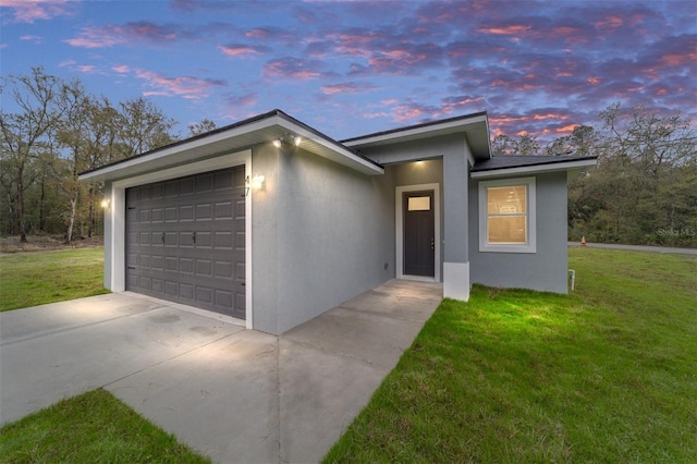 view of front of home with a front lawn, an attached garage, and stucco siding