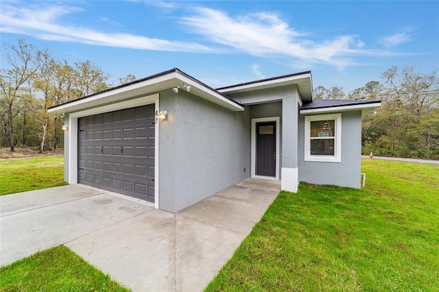 view of front of house featuring an attached garage, driveway, a front lawn, and stucco siding