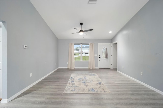 foyer entrance with ceiling fan, light hardwood / wood-style floors, and vaulted ceiling