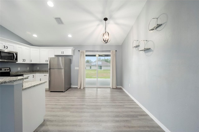 kitchen featuring lofted ceiling, pendant lighting, stainless steel appliances, white cabinets, and light stone countertops