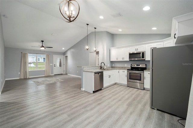 kitchen with white cabinetry, kitchen peninsula, stainless steel appliances, decorative light fixtures, and sink