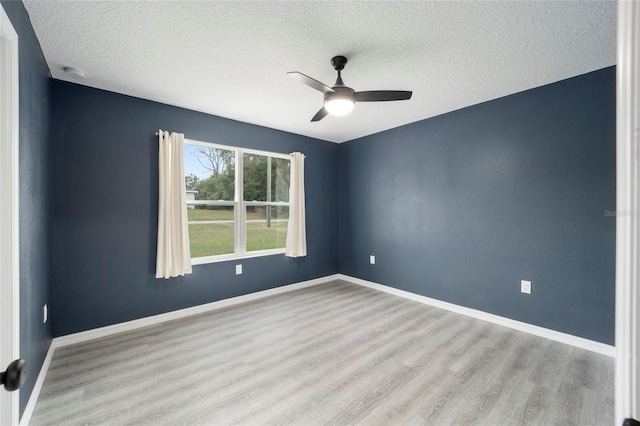 spare room featuring light hardwood / wood-style floors, ceiling fan, and a textured ceiling