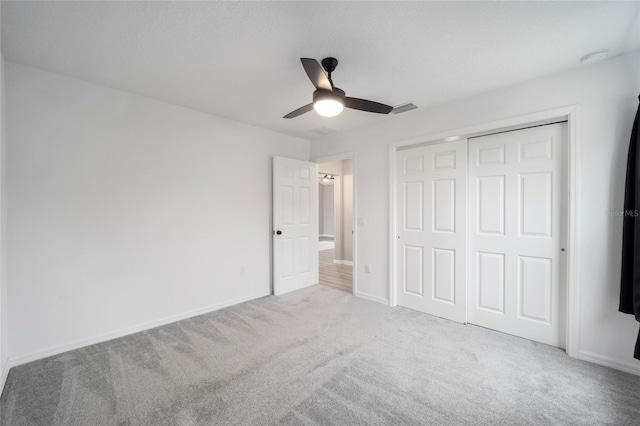 unfurnished bedroom featuring ceiling fan, light carpet, and a closet