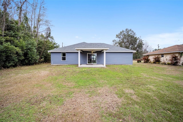 back of property with a yard and a patio area