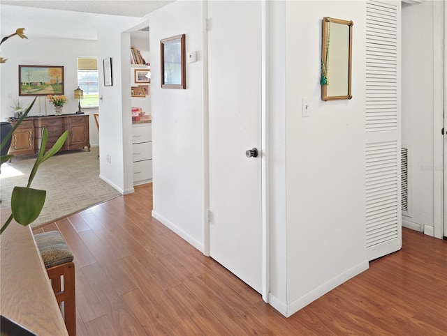 corridor with hardwood / wood-style floors