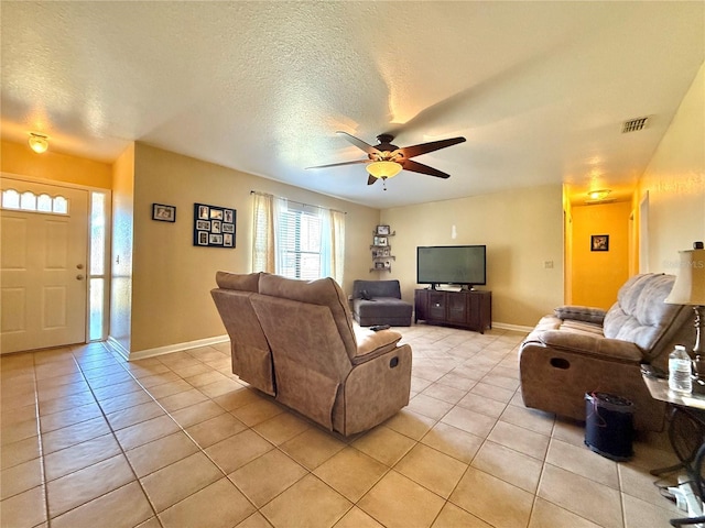 tiled living room featuring ceiling fan and a textured ceiling