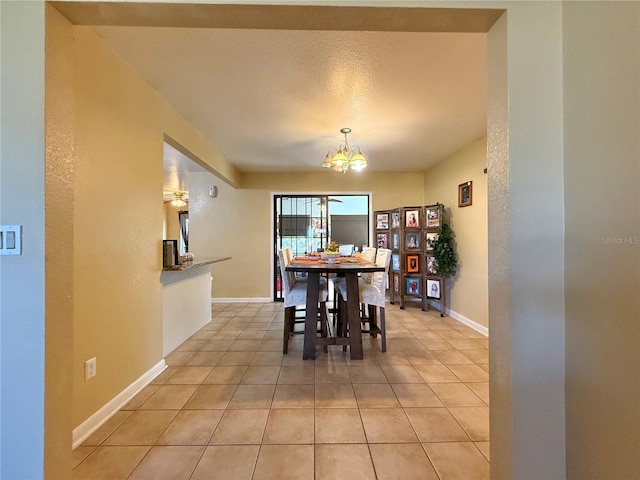 dining area with light tile patterned flooring, a chandelier, and a textured ceiling