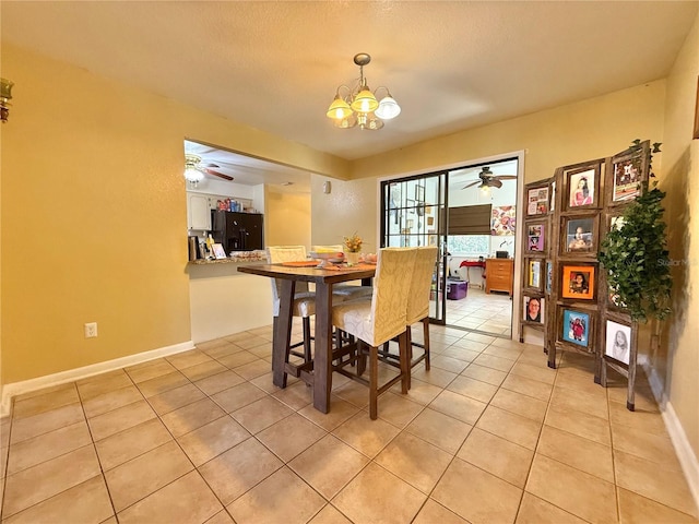 dining space featuring ceiling fan with notable chandelier, a textured ceiling, and light tile patterned floors