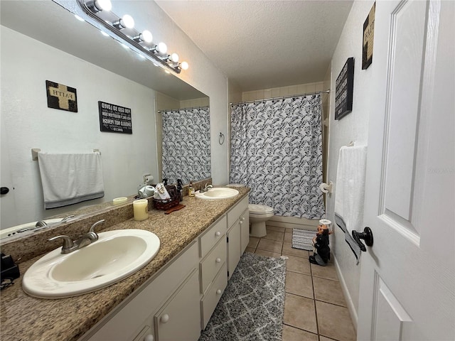 bathroom with curtained shower, vanity, toilet, tile patterned floors, and a textured ceiling