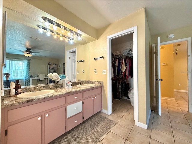 bathroom featuring ceiling fan, tile patterned floors, vanity, and a textured ceiling