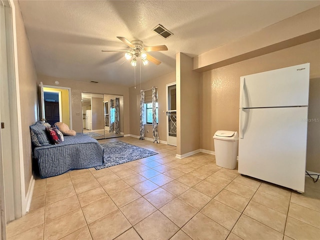 living room featuring light tile patterned floors, a textured ceiling, and ceiling fan