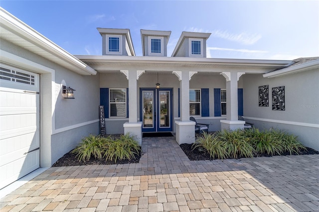 view of exterior entry featuring covered porch and french doors