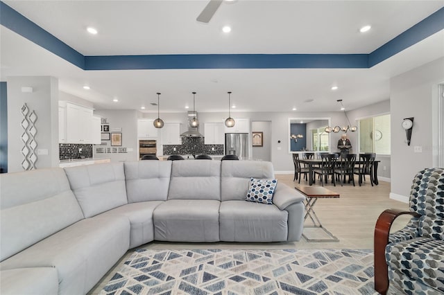 living room featuring ceiling fan and light hardwood / wood-style floors