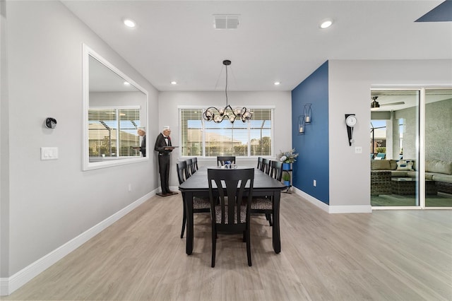 dining area with plenty of natural light, a chandelier, and light wood-type flooring