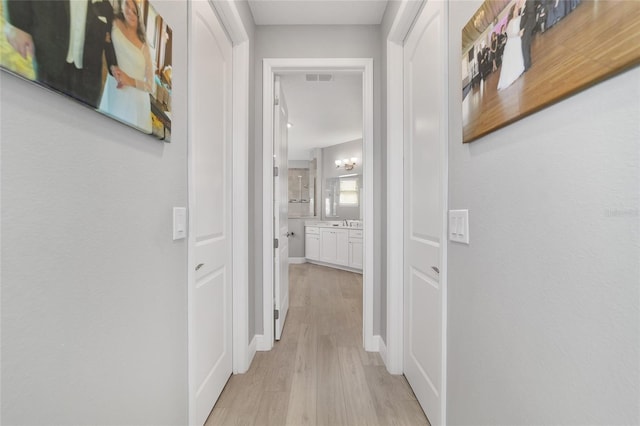 hall with sink and light hardwood / wood-style flooring