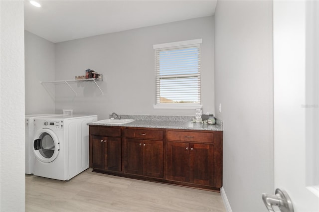 laundry area featuring sink and light hardwood / wood-style floors