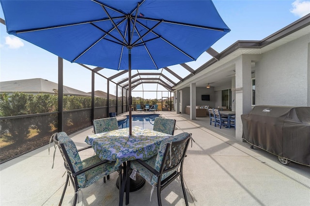 view of patio with area for grilling, an outdoor living space, ceiling fan, and glass enclosure