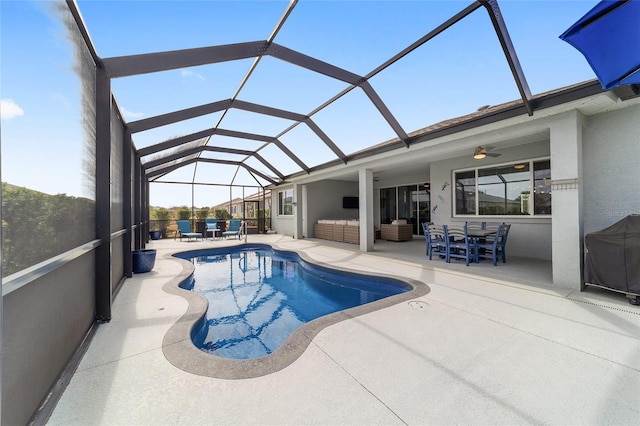 view of swimming pool featuring area for grilling, ceiling fan, glass enclosure, an outdoor living space, and a patio area