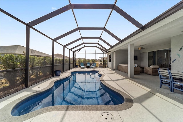 view of swimming pool featuring an outdoor living space, a patio, ceiling fan, and glass enclosure