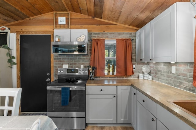 kitchen with stainless steel appliances, white cabinetry, lofted ceiling, and wooden ceiling