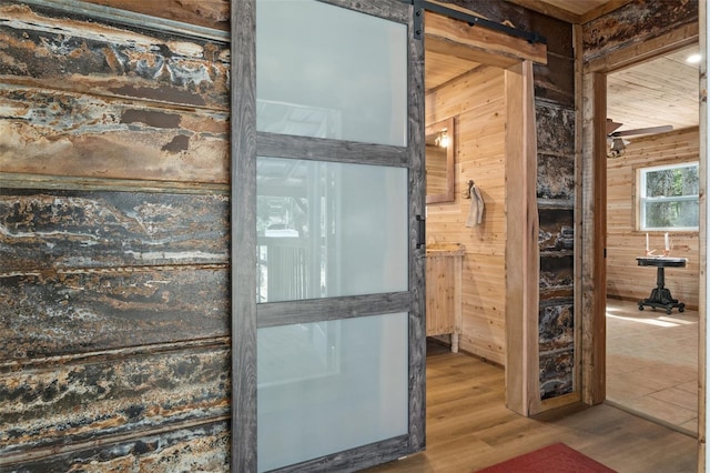 bathroom featuring hardwood / wood-style flooring and wooden walls