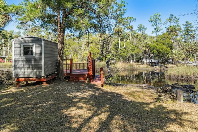 view of yard featuring a water view and a storage shed