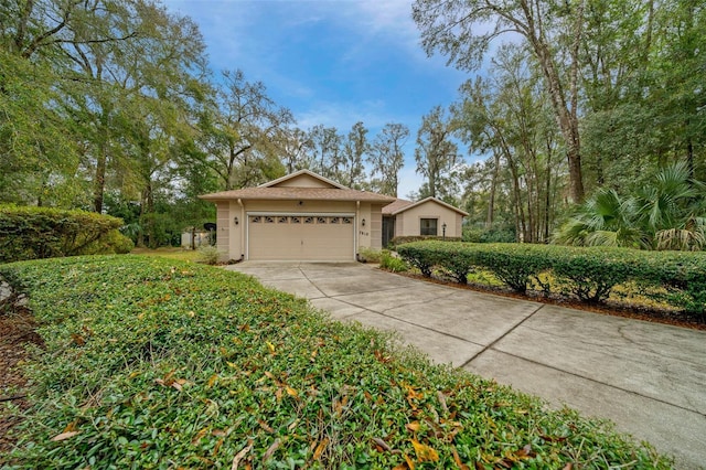 view of front of house featuring a garage, concrete driveway, and stucco siding