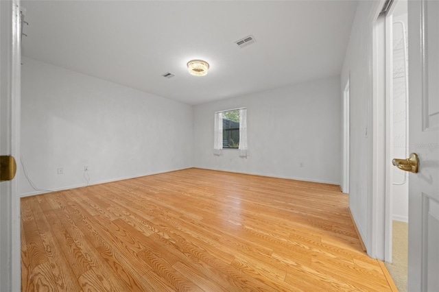 spare room with baseboards, visible vents, and light wood-type flooring