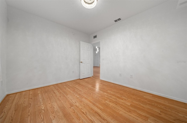 spare room with visible vents, light wood-type flooring, and baseboards