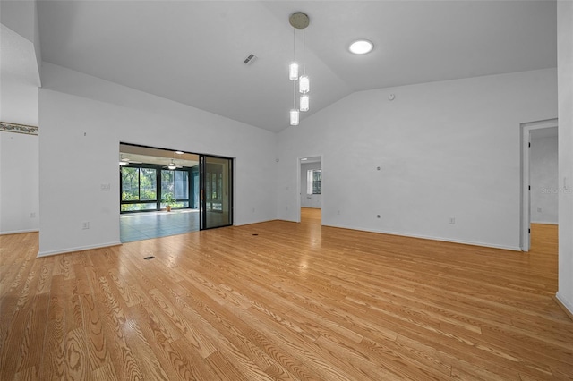 spare room featuring visible vents, baseboards, light wood-style floors, and high vaulted ceiling