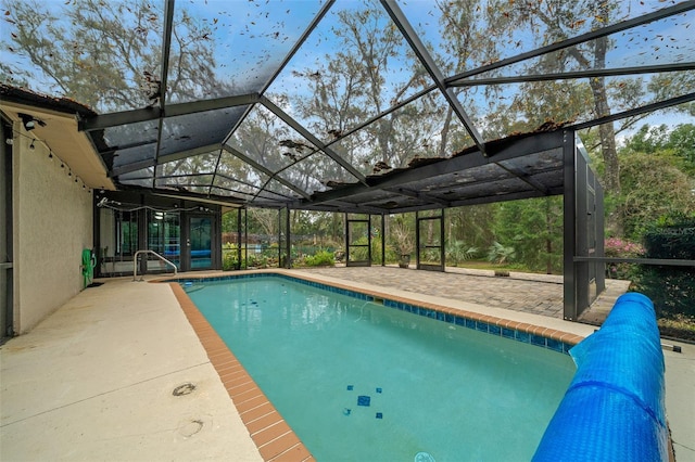 pool with glass enclosure and a patio area