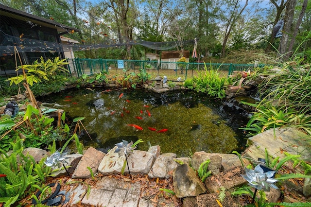 view of yard with a garden pond and fence