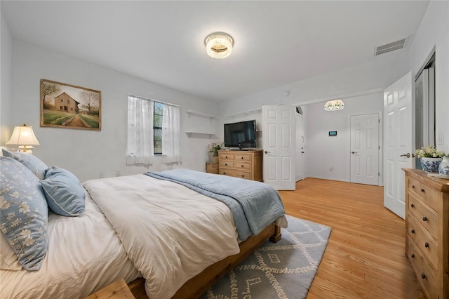 bedroom with visible vents, light wood-style flooring, and baseboards