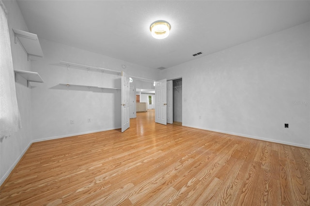 interior space with light wood-style flooring, baseboards, visible vents, and a closet