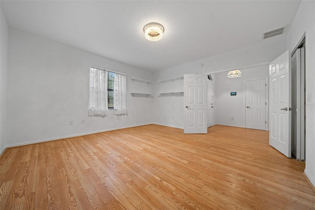 spare room with baseboards, visible vents, and light wood-type flooring