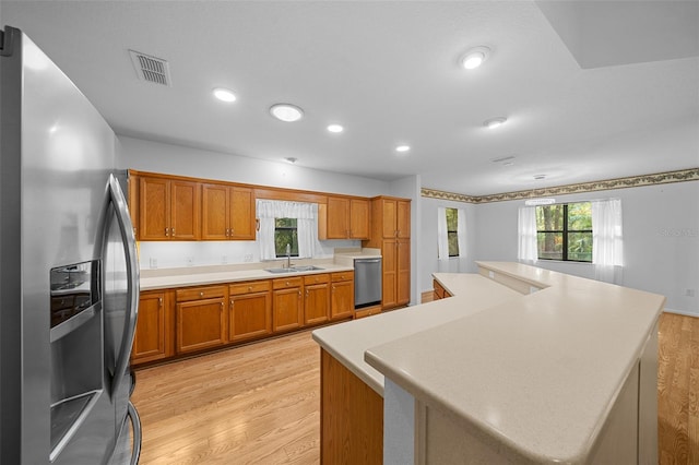 kitchen featuring light wood-style floors, visible vents, appliances with stainless steel finishes, and a sink