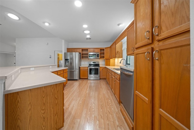 kitchen with brown cabinets, open shelves, a sink, light wood-style floors, and appliances with stainless steel finishes