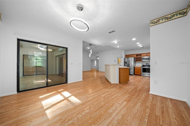 kitchen featuring visible vents, open floor plan, light wood-type flooring, brown cabinetry, and stainless steel appliances