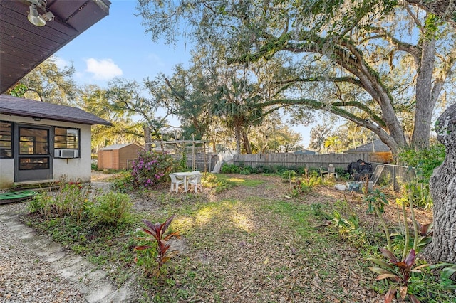 view of yard with a fenced backyard, a storage unit, and an outdoor structure