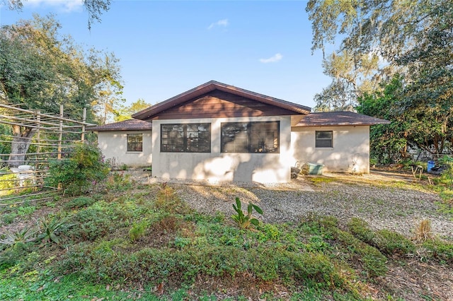 rear view of property featuring stucco siding