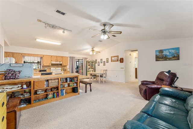 living room featuring light carpet, visible vents, ceiling fan, vaulted ceiling, and track lighting