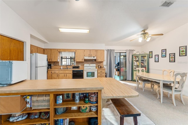 kitchen with lofted ceiling, white appliances, under cabinet range hood, and light countertops