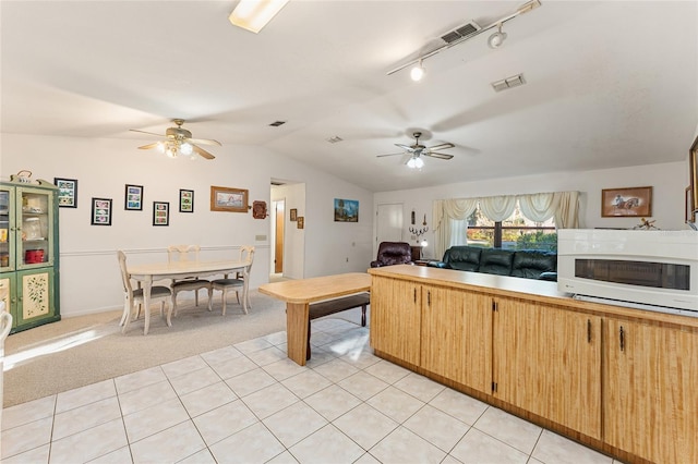 kitchen with white microwave, light carpet, visible vents, vaulted ceiling, and open floor plan