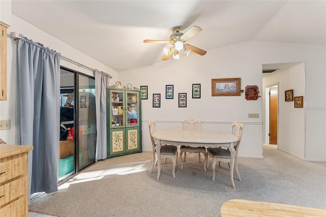 dining room with light carpet, ceiling fan, and vaulted ceiling