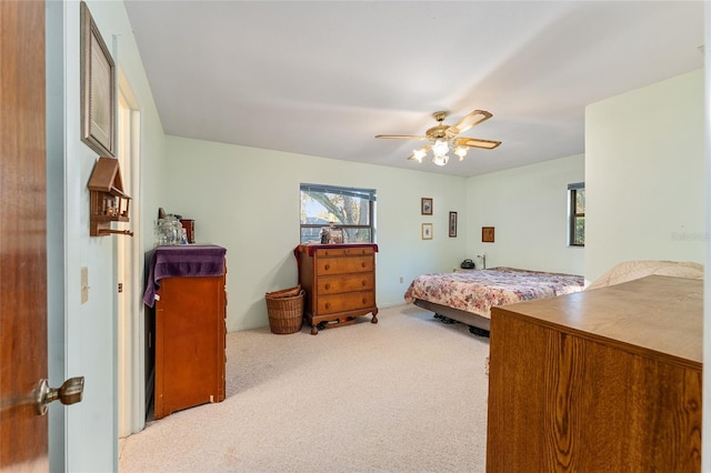 bedroom featuring a ceiling fan and light colored carpet