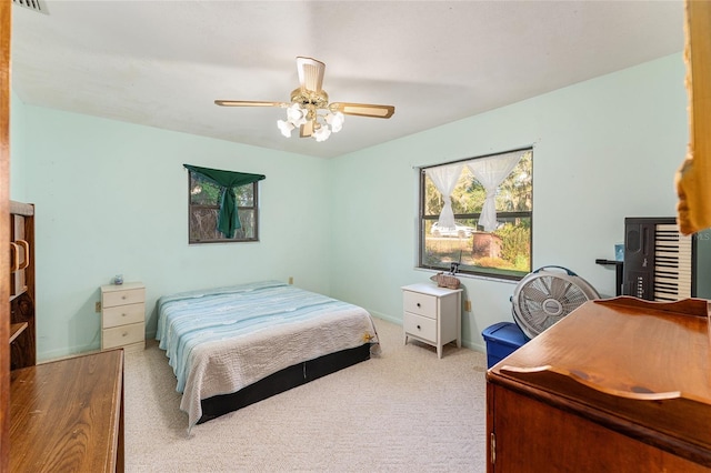 bedroom with ceiling fan, baseboards, visible vents, and light colored carpet